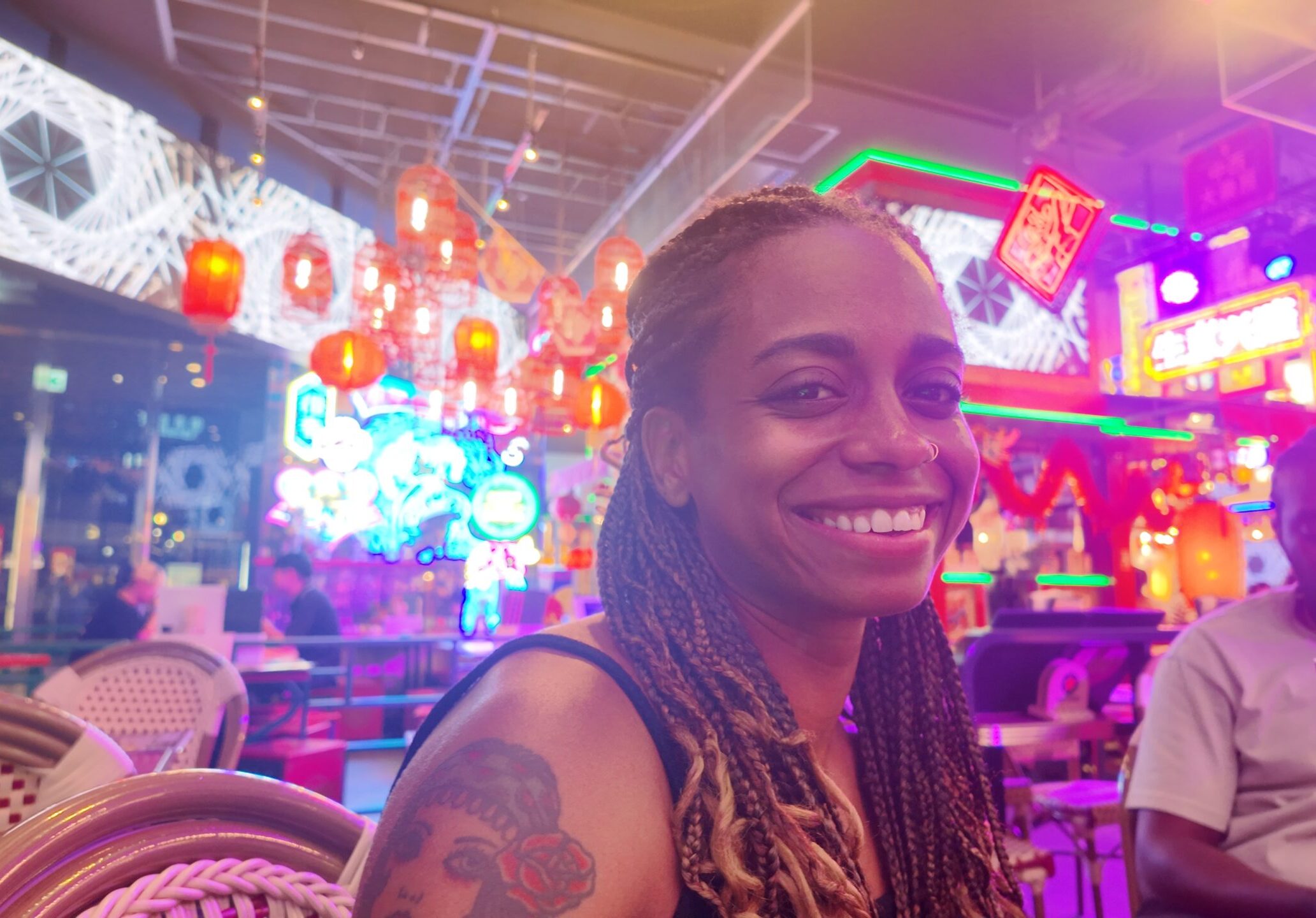 Bekah smiling in a neon-lit restaurant with red lanterns.